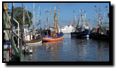 Behind some shrimping boats we can see the white ferry to the neighbouring island of Spiekeroog